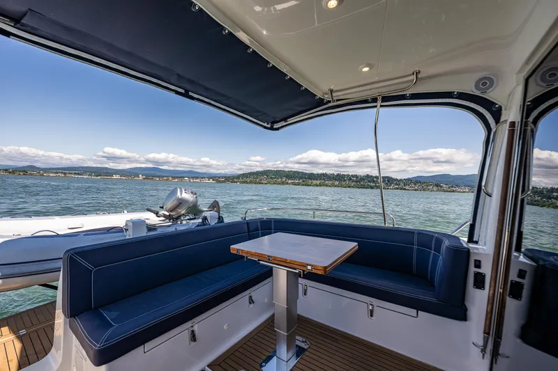Slide: The Image of Luxurious seating area on 2021 Nimbus 405 Coupé yacht, overlooking serene waters and scenic landscape. - 10