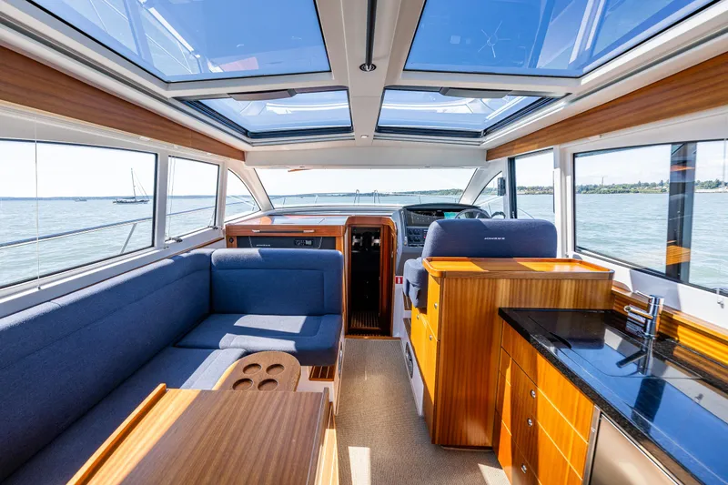 Slide: The Image of Luxurious interior of 2021 Nimbus 405 Coupé yacht with panoramic windows and elegant wood finishes. - 14