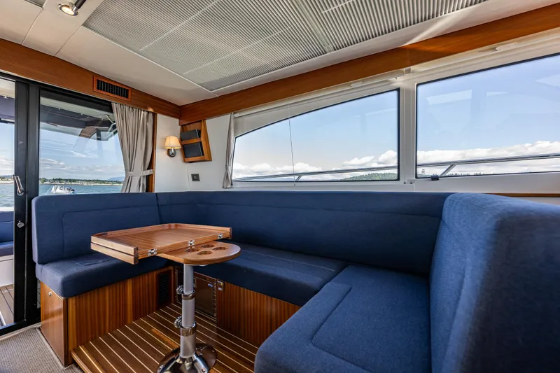 Slide: The Image of Luxurious interior of 2021 Nimbus 405 Coupé yacht with blue seating and wooden table. - 16