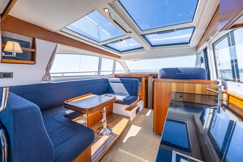 Slide: The Image of Luxurious interior of 2021 Nimbus 405 Coupé yacht with skylights and elegant seating. - 17