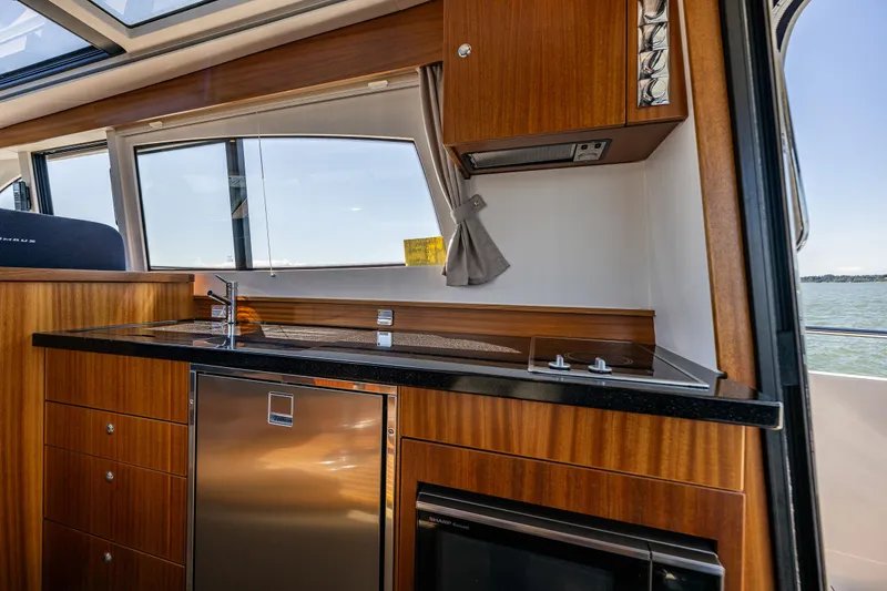 Slide: The Image of Luxurious kitchen interior of 2021 Nimbus 405 Coupé yacht with wood finish and modern appliances. - 20