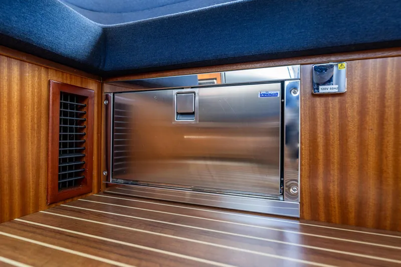 Slide: The Image of Interior of 2021 Nimbus 405 Coupé, featuring a stainless steel appliance and wooden finish. - 22