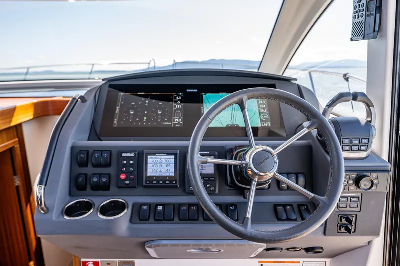 Slide: The Image of Steering wheel and dashboard of 2021 Nimbus 405 Coupé yacht, featuring navigation controls. - 25