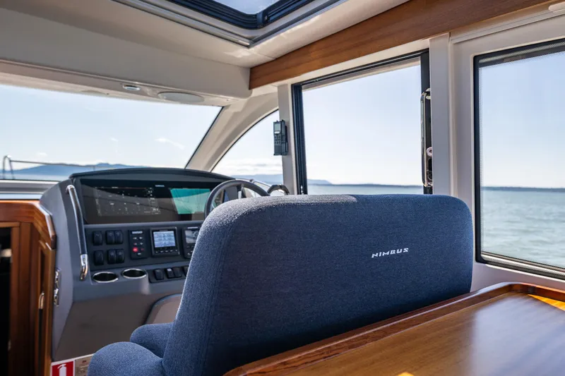 Slide: The Image of Interior of 2021 Nimbus 405 Coupé yacht, featuring helm and ocean view. - 29