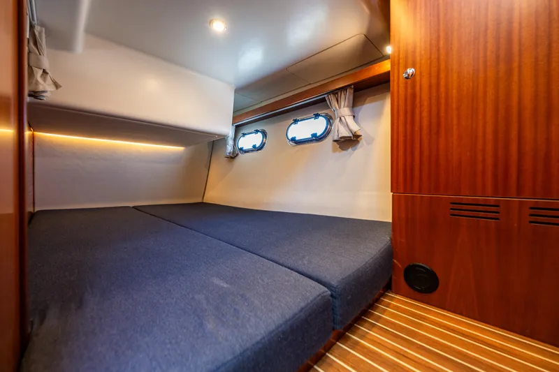 Slide: The Image of Cozy cabin interior of 2021 Nimbus 405 Coupé yacht with wooden accents and blue bedding. - 42