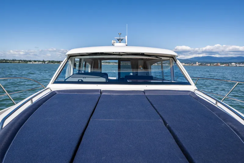 Slide: The Image of Nimbus 405 Coupé #88, 2021 model, cruising on a serene lake under a clear blue sky. - 6