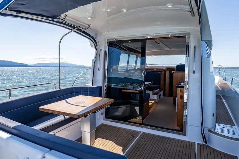 Slide: The Image of Luxurious 2021 Nimbus 405 Coupé yacht interior with ocean view and elegant seating area. - 7