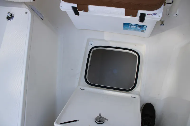 Slide: The Image of 2025 Pioneer 220 Bay Sport boat interior with storage compartment and cooler. - 11