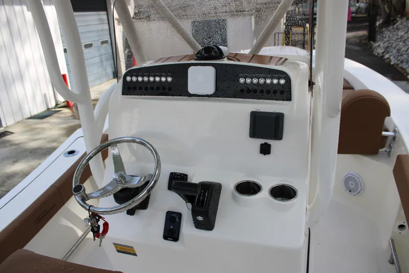 Slide: The Image of 2025 Pioneer 220 Bay Sport boat console with steering wheel and controls. - 13