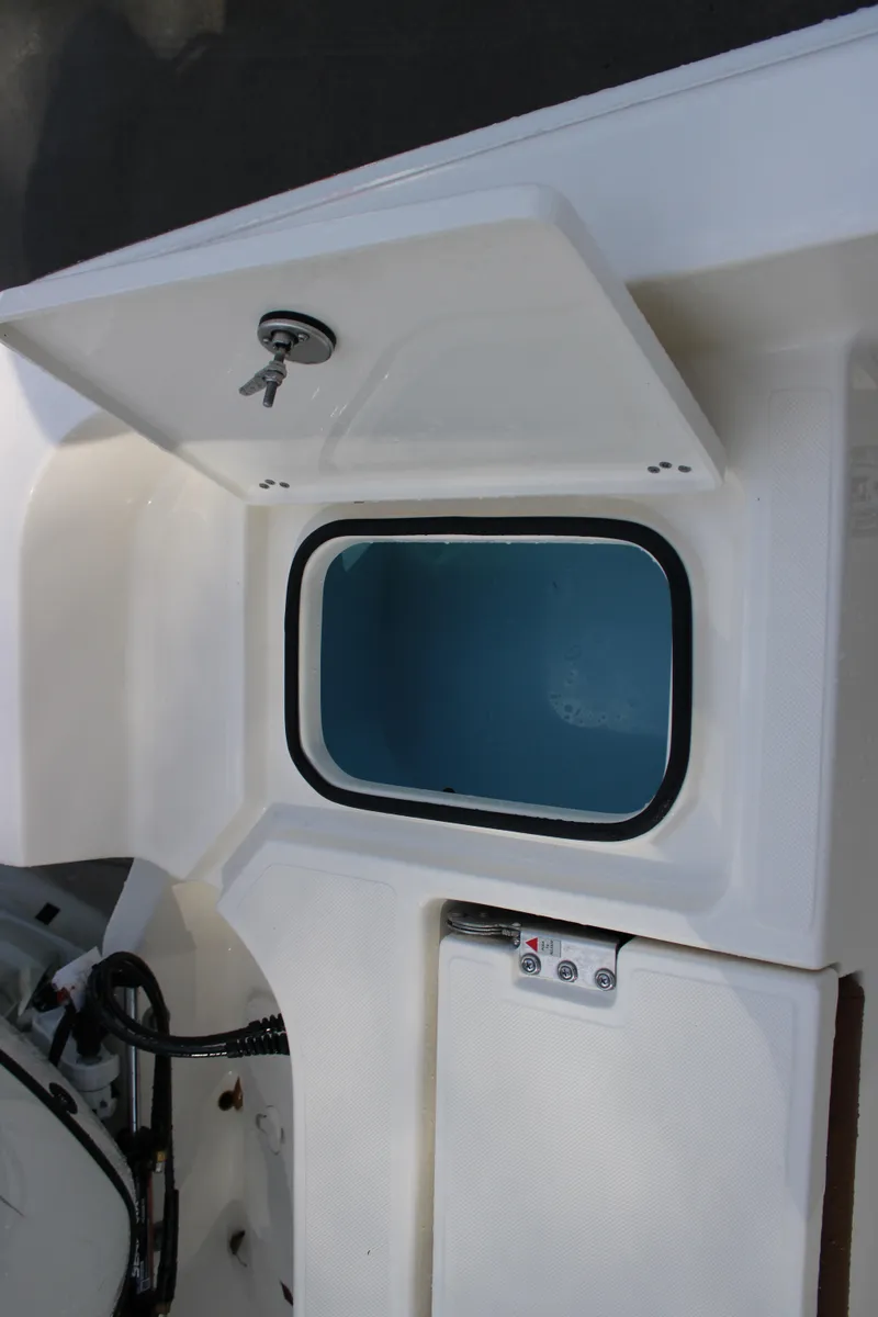 Slide: The Image of 2025 Pioneer 220 Bay Sport boat storage compartment with open hatch and visible interior. - 16