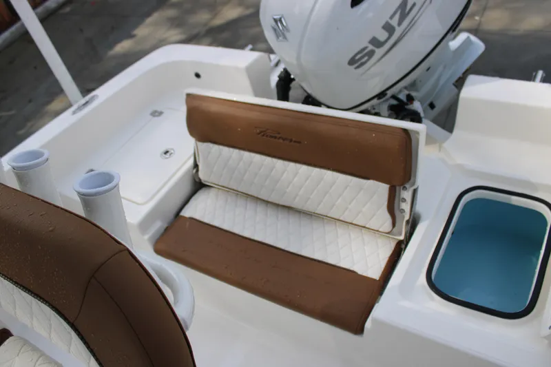 Slide: The Image of 2025 Pioneer 220 Bay Sport boat interior with brown and white seating, Suzuki engine visible. - 17