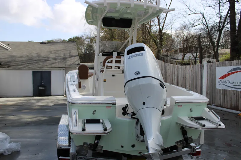 Slide: The Image of 2025 Pioneer 220 Bay Sport boat with powerful outboard motor, parked outdoors. - 20