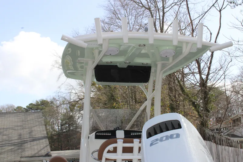 Slide: The Image of 2025 Pioneer 220 Bay Sport boat with T-top and 200 horsepower engine, outdoors. - 21