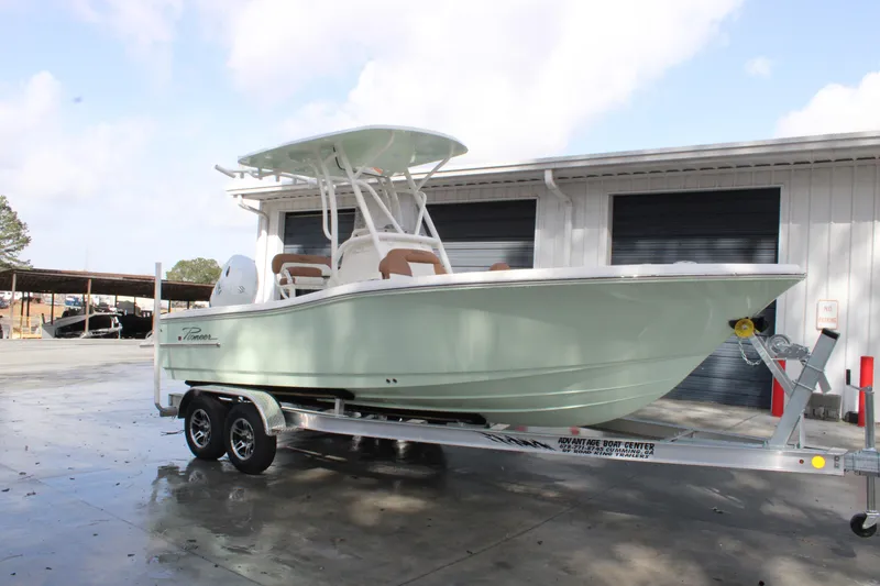 Slide: The Image of 2025 Pioneer 220 Bay Sport boat on trailer, parked outside a garage. - 4