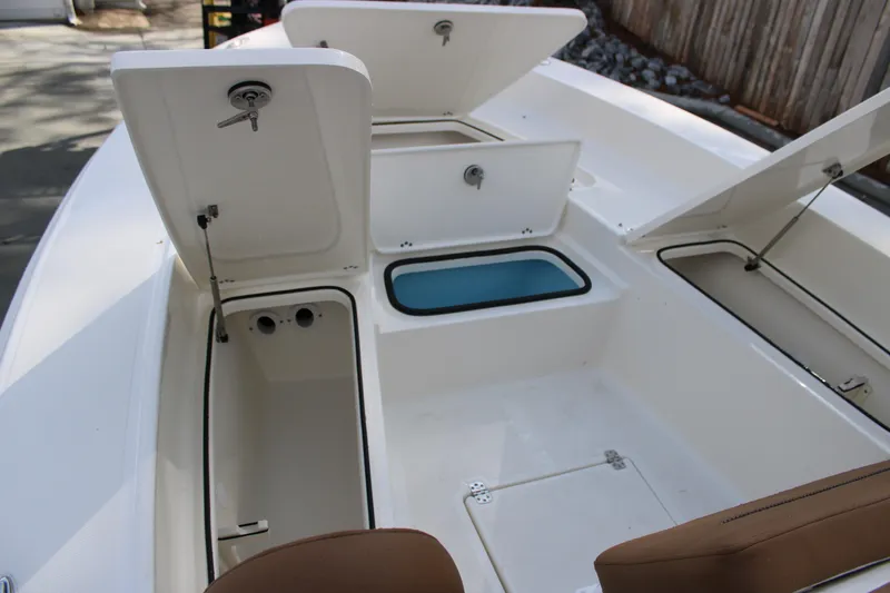 Slide: The Image of 2025 Pioneer 220 Bay Sport boat with open storage compartments and seating. - 8