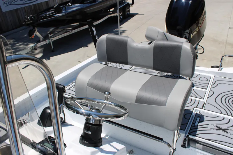 Slide: The Image of 2026 Xpress H22B Bay boat interior with gray seating and steering wheel. - 10