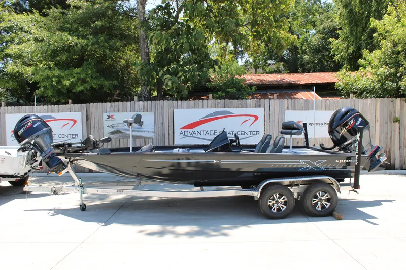 Slide: The Image of 2026 Xpress H18 boat on trailer, parked outdoors at Advantage Boat Center. - 17