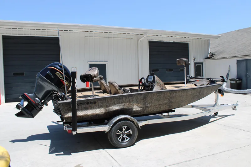 Slide: The Image of 2026 Xpress H18 boat with motor on trailer, parked outside a garage. - 3