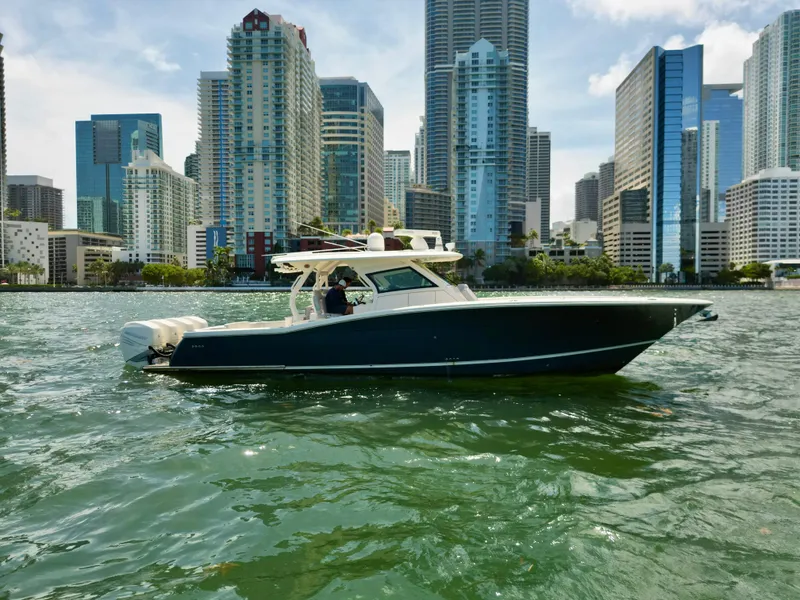 Slide: The Image of 2021 Scout 380 LXF boat cruising near city skyline. - 11