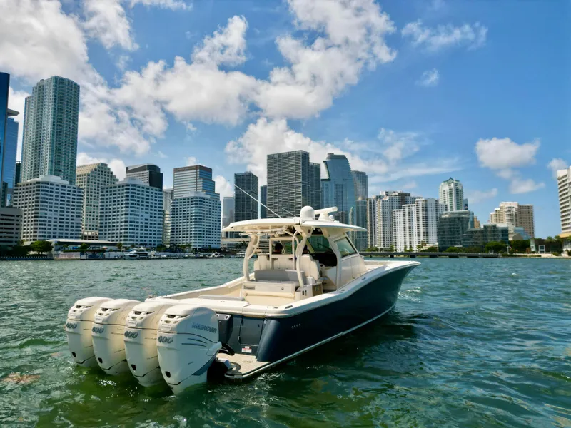 Slide: The Image of 2021 Scout 380 LXF boat on water with city skyline background. - 13