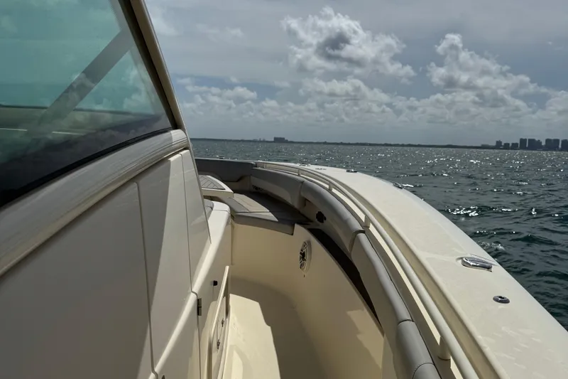Slide: The Image of 2021 Scout 380 LXF boat cruising on open water under a cloudy sky. - 27