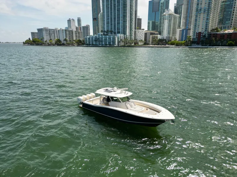 Slide: The Image of 2021 Scout 380 LXF boat on water with city skyline background. - 3