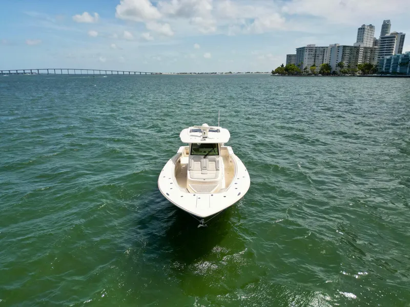 Slide: The Image of 2021 Scout 380 LXF boat on open water near city skyline. - 4