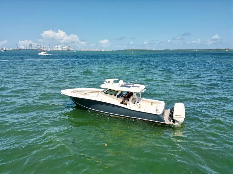 Slide: The Image of 2021 Scout 380 LXF boat cruising on open water under clear blue skies. - 6