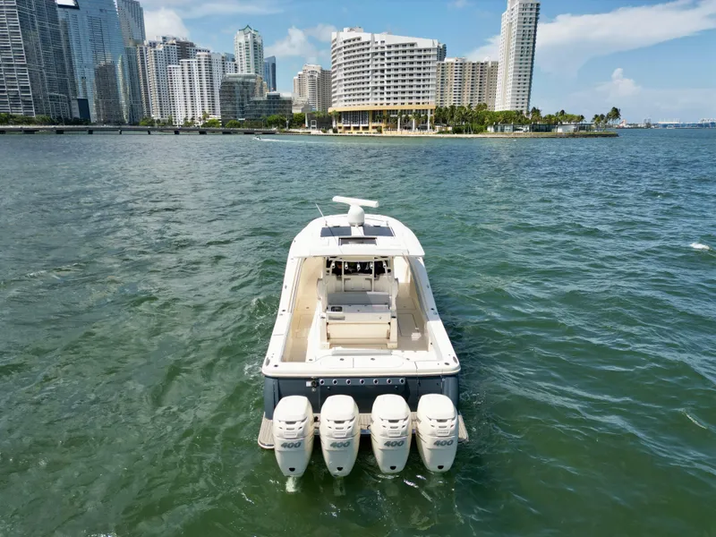 Slide: The Image of 2021 Scout 380 LXF boat on water with city skyline in background. - 8