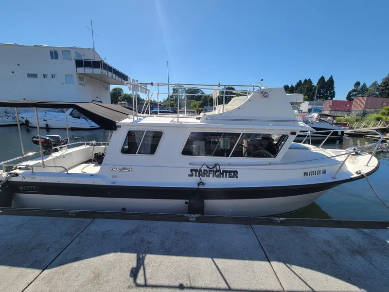 Slide: The Image of 2001 SeaSport 2700 Navigator boat docked at marina under clear blue sky. - 1