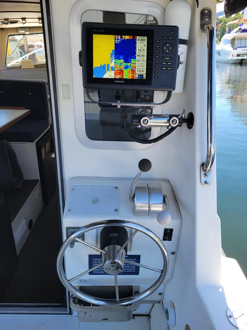 Slide: The Image of 2001 SeaSport 2700 Navigator helm with Garmin navigation system and steering wheel. - 12