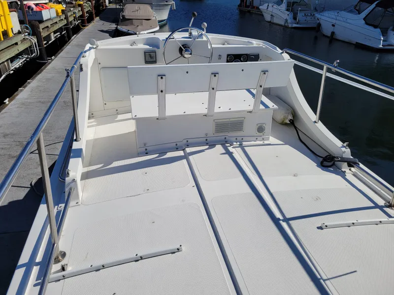 Slide: The Image of 2001 SeaSport 2700 Navigator boat deck with steering wheel, docked at marina. - 14