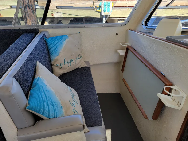 Slide: The Image of Interior of a 2001 SeaSport 2700 Navigator with cozy seating and decorative pillows. - 19
