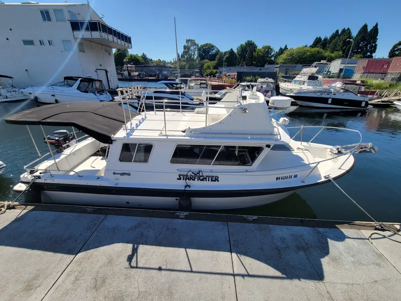 Slide: The Image of 2001 SeaSport 2700 Navigator boat docked at marina under clear blue sky. - 2