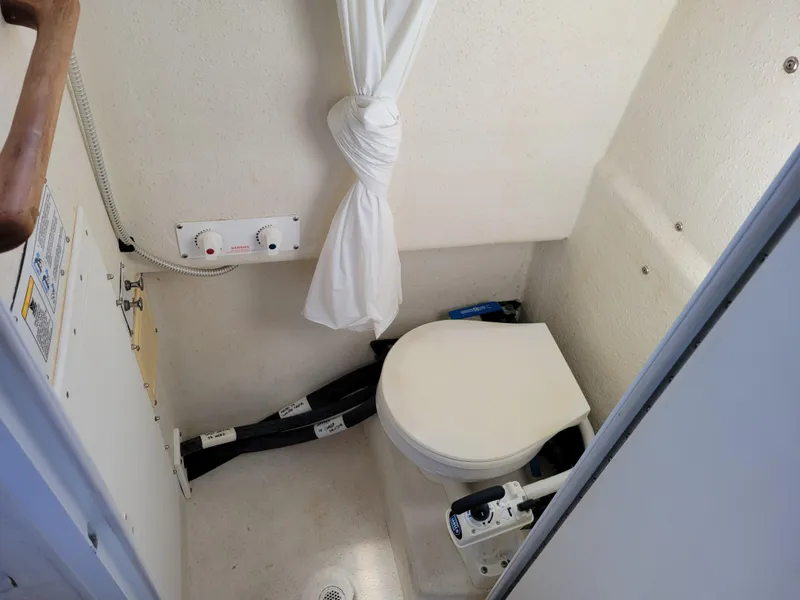 Slide: The Image of Compact marine bathroom in 2001 SeaSport 2700 Navigator boat, featuring a white toilet and shower. - 21
