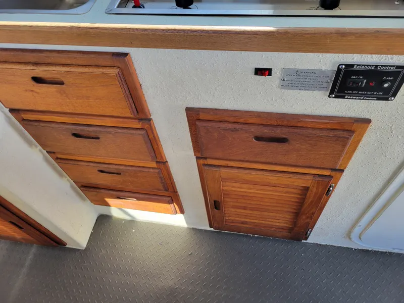Slide: The Image of Wooden cabinetry and control panel inside a 2001 SeaSport 2700 Navigator boat. - 24