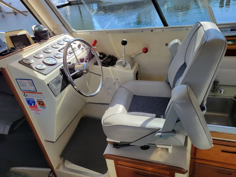 Slide: The Image of 2001 SeaSport 2700 Navigator helm with steering wheel and control panel. - 25