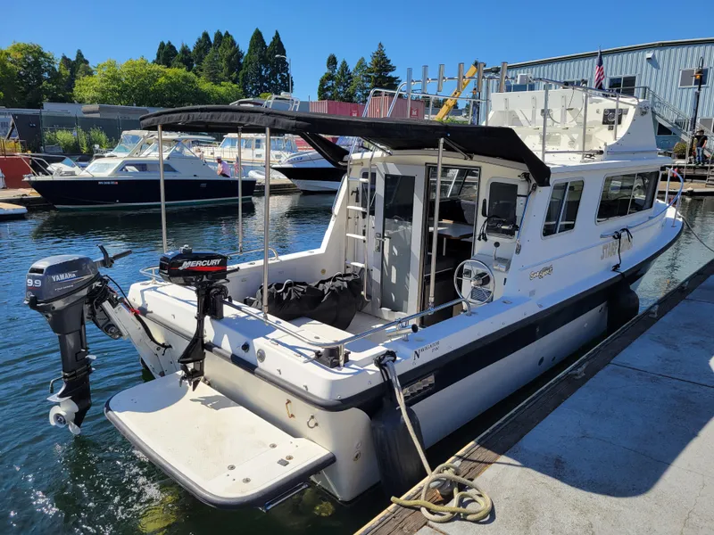 Slide: The Image of 2001 SeaSport 2700 Navigator boat docked with dual outboard motors. - 3