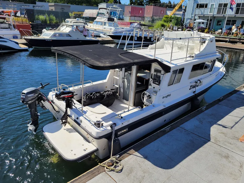 Slide: The Image of 2001 SeaSport 2700 Navigator boat docked at marina, featuring outboard motors and canopy. - 5