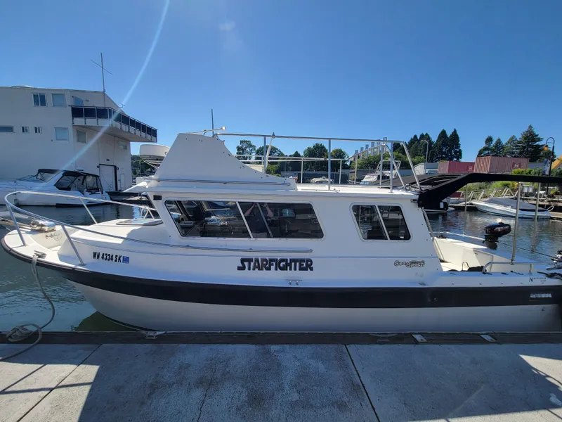 Slide: The Image of 2001 SeaSport 2700 Navigator boat docked, named "Starfighter," under clear blue sky. - 7