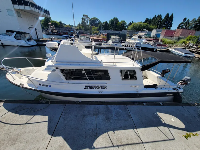 Slide: The Image of 2001 SeaSport 2700 Navigator boat docked at marina, named "Starfighter." - 8