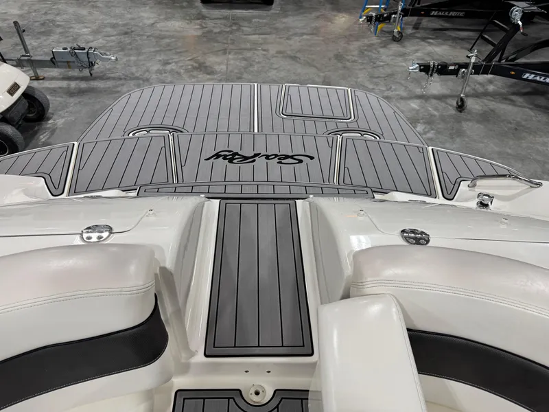 Slide: The Image of 2005 Sea Ray 290 SLX boat interior with gray decking and white seating. - 10