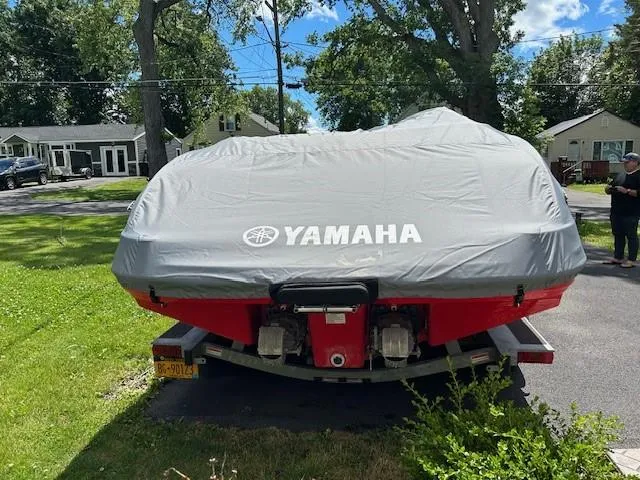 Slide: The Image of 2008 Yamaha Jet boat covered, parked on a driveway with trees and houses in the background. - 4