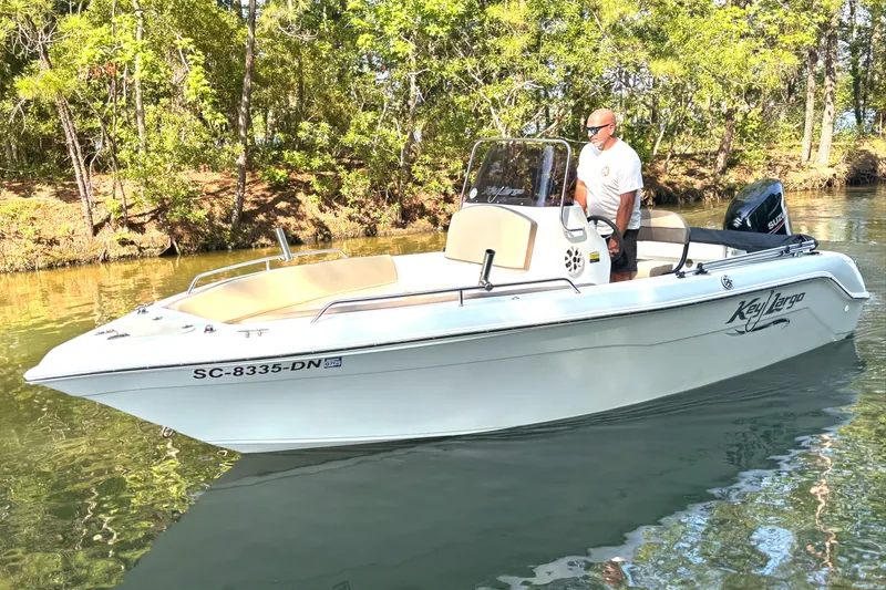 Slide: The Image of A 2019 Key Largo 2000 boat on a calm river with a person steering. - 0