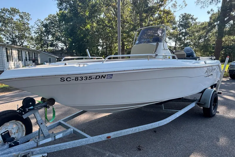 Slide: The Image of White 2019 Key Largo 2000 boat on trailer, parked on a sunny residential street. - 12