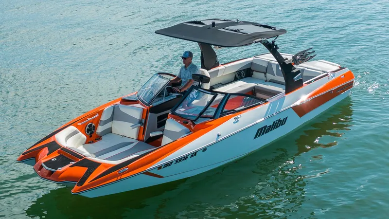 Slide: The Image of 2018 Malibu Wakesetter 24 MXZ boat on water, featuring sleek design and vibrant orange accents. - 1