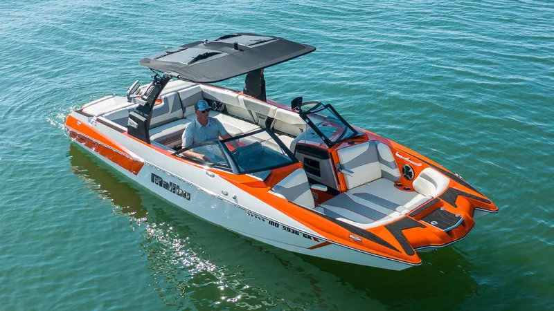 Slide: The Image of 2018 Malibu Wakesetter 24 MXZ boat on water, featuring orange and white design. - 2