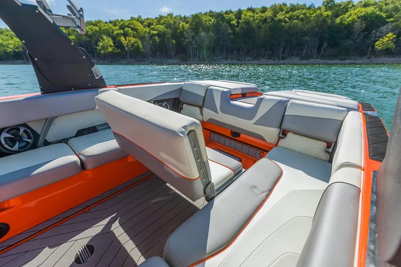 Slide: The Image of 2018 Malibu Wakesetter 24 MXZ interior with gray and orange seating on a lake. - 7