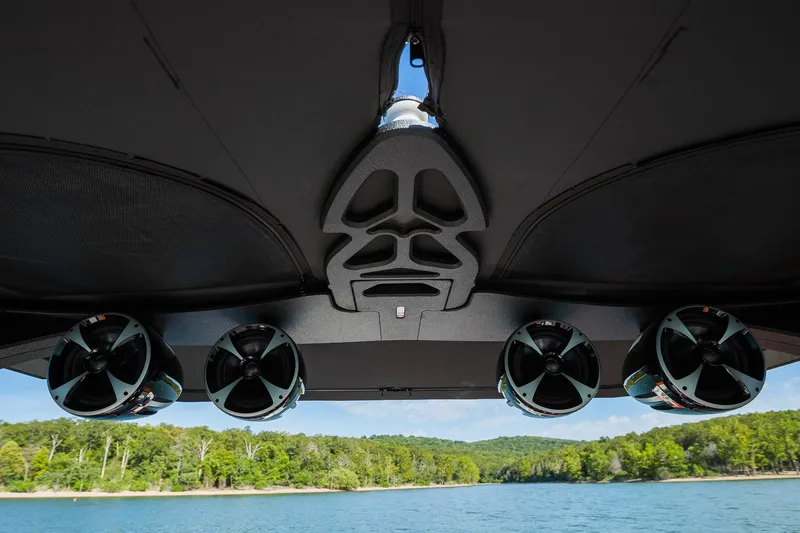 Slide: The Image of 2018 Malibu Wakesetter 24 MXZ boat speakers and canopy, overlooking a scenic lake view. - 9