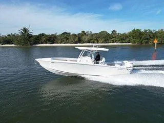 The Image of 2018 Jupiter 30 HFS boat cruising on a calm lake with lush greenery. - 0